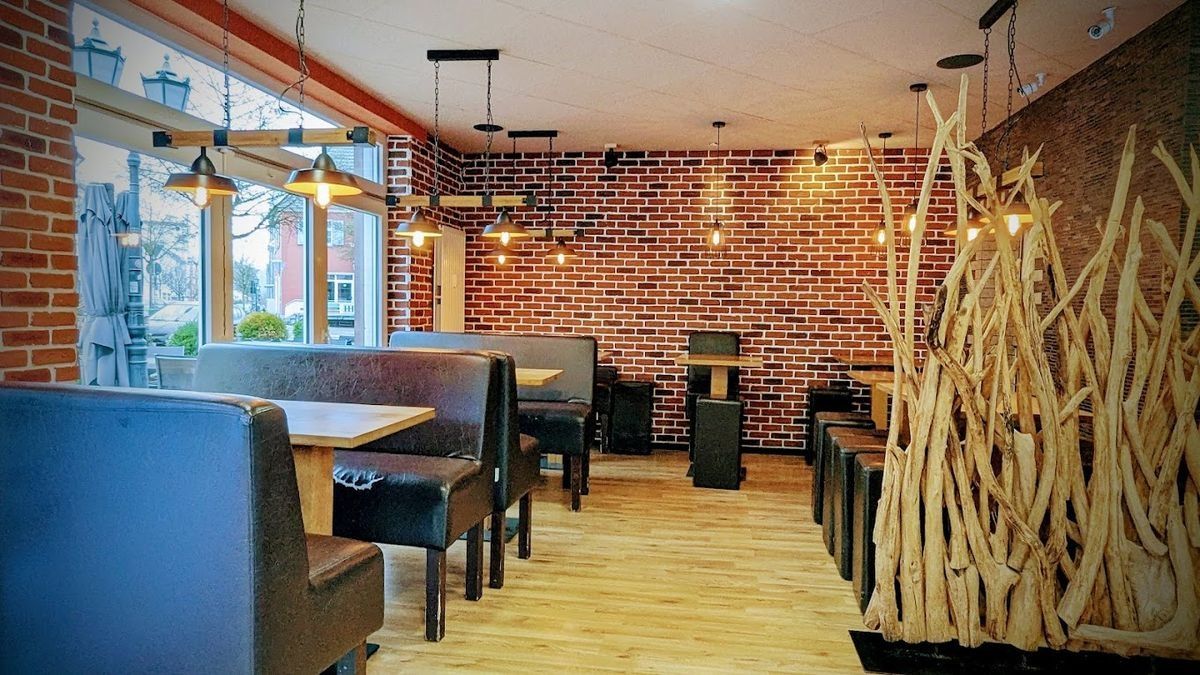 Gastraum von Akifs Bistro mit Backsteinwand und Holzelementen